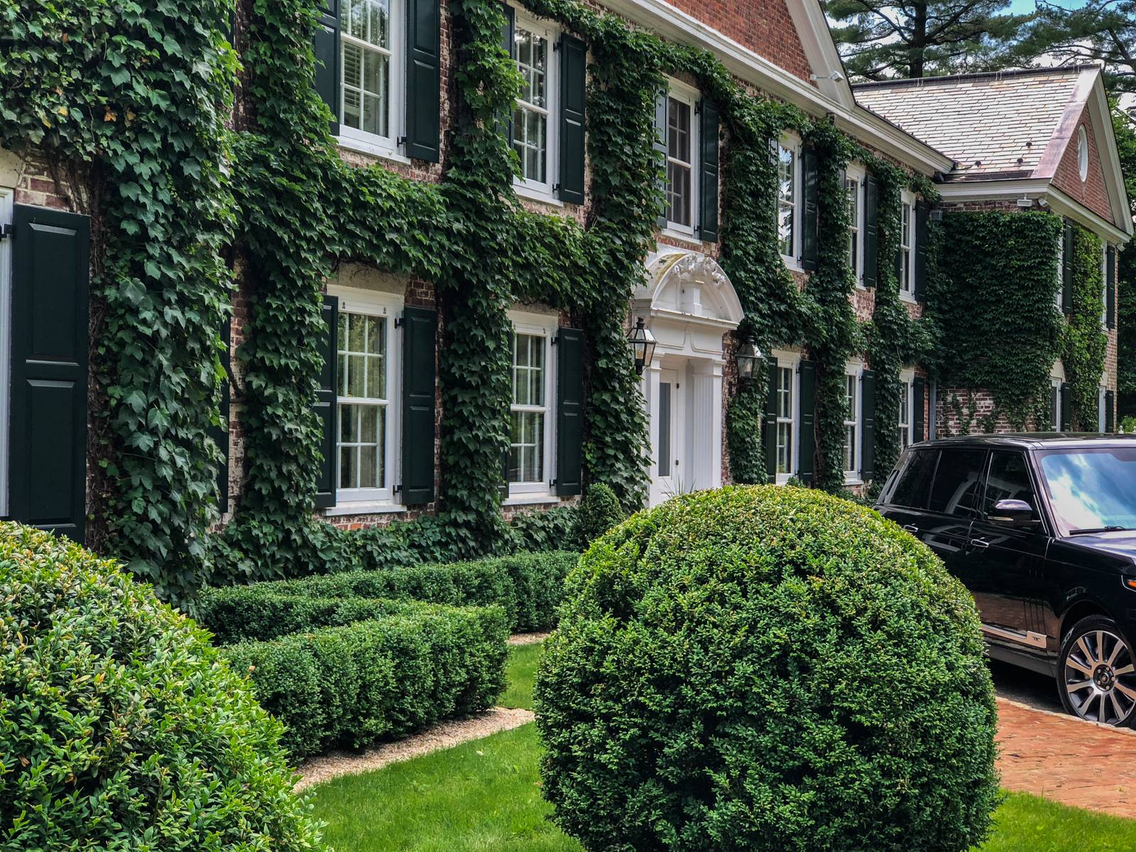 Ivy-covered brick facade with boxwood